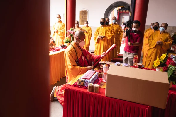 インドネシア バンドン 2022年1月8日仏寺内の祭壇前でオレンジの服を着た僧侶が一緒に祈る — ストック写真