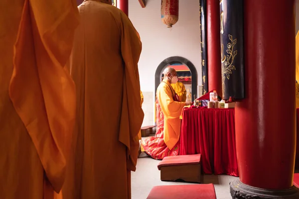 インドネシア バンドン 2022年1月8日仏寺内の祭壇前でオレンジの服を着た僧侶が一緒に祈る — ストック写真