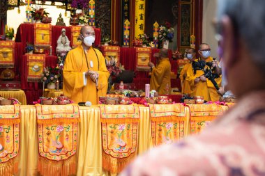 Bandung, Endonezya - 8 Ocak 2022: Cemaat ve keşişler mihrapta Buda tapınağının içindeki tanrıya saygı göstermek için birlikte dua ederken