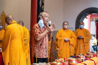 Bandung, Endonezya - 8 Ocak 2022: Cemaat ve keşişler mihrapta Buda tapınağının içindeki tanrıya saygı göstermek için birlikte dua ederken