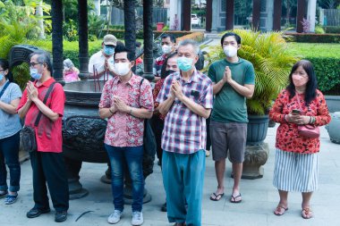 Bandung, Endonezya - 8 Ocak 2022: Cemaat ve keşişler mihrapta Buda tapınağının içindeki tanrıya saygı göstermek için birlikte dua ederken