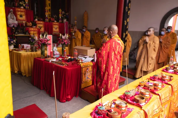 インドネシア バンドン2022年1月8日 仏殿内の祭壇でオレンジと赤の衣を着た僧侶の集団 — ストック写真