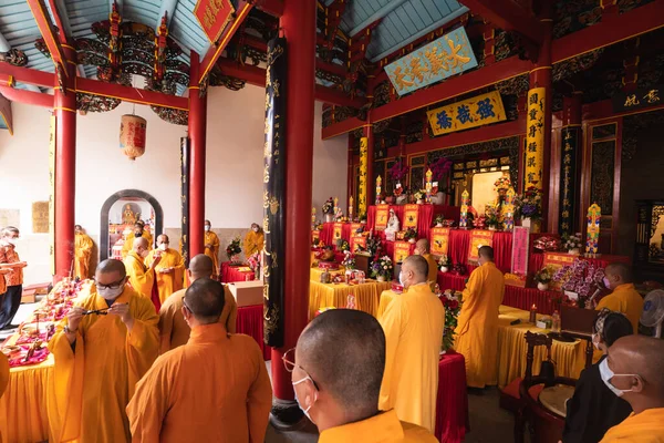 インドネシア バンドン2022年1月8日 仏殿内の祭壇でオレンジと赤の衣を着た僧侶の集団 — ストック写真
