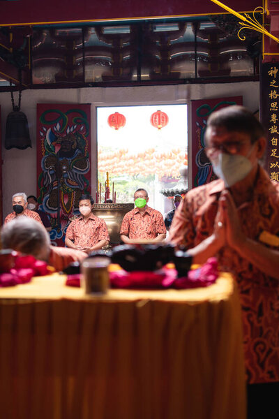 Bandung, Indonesia - January 8, 2022 : The visitor praying together with the monks in front of the offerings to the god at the Buddha temple