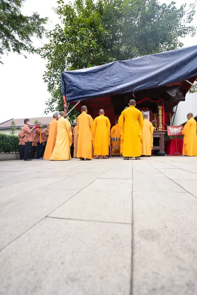2022年1月8日 2022年1月8日 インドネシア バンドン 中国の町にある仏寺内の祭壇で神に祈願しながらオレンジの衣を着た僧侶が立ち上がる — ストック写真