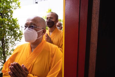 Bandung, Endonezya - 8 Ocak 2022: Keşişler mihrapta toplanıp Buda sunağının içindeki cemaatle dua ediyorlar.