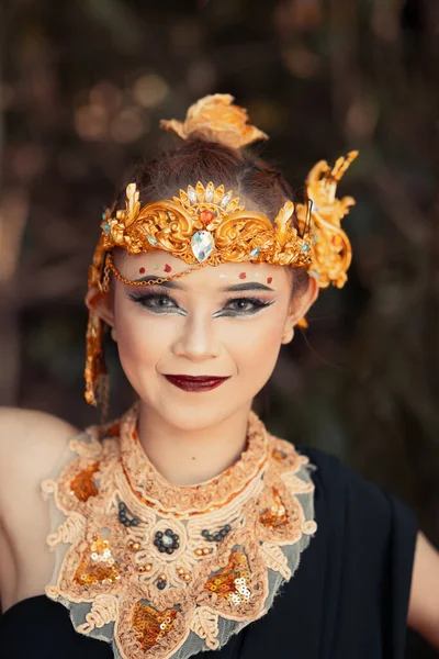 身着金色王冠和金色项链的巴厘女人 在森林里有着美丽的脸庞 — 图库照片