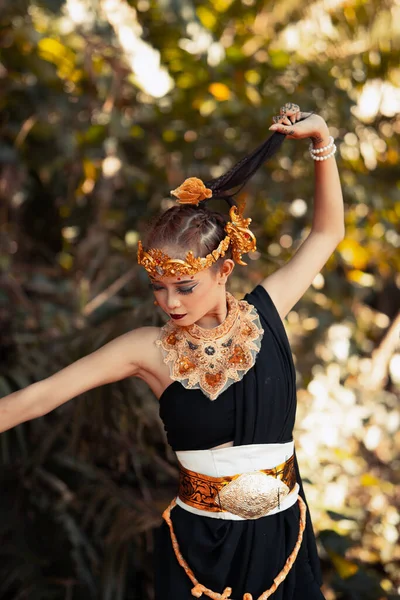 Piękna Balijka Trzymająca Czarne Włosy Podczas Pozowania Czarnej Sukience Tanecznej — Zdjęcie stockowe
