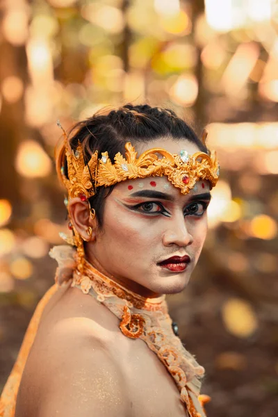 一个亚洲男人满脸怒容 头上戴着金色的王冠 赤身裸体 双手插在丛林中 — 图库照片