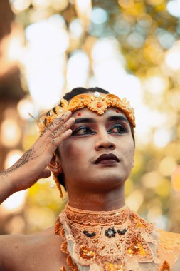 Siyah göz farı takan Asyalı erkekler ve köyün içinde kafasına altın bir taç takarken yüzünde kırmızı siyah dudaklar vardı.