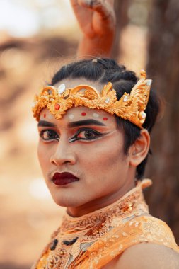 Altın tacı olan bir kral ormanda ağacın önünde dans ediyordu.