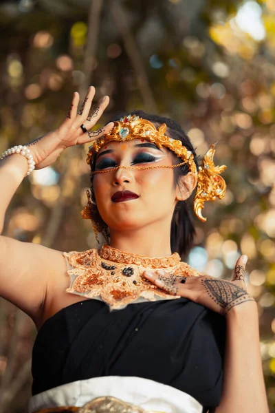 一位漂亮的爪哇女人穿着黑色服装摆姿势 同时在森林里戴着金色的皇冠和金色的项链 — 图库照片