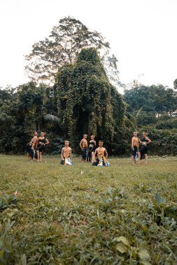 Taylandlı bir grup altın bir kostüm içinde köyün içinde ormanın içinde gösteri yaparken poz veriyor.