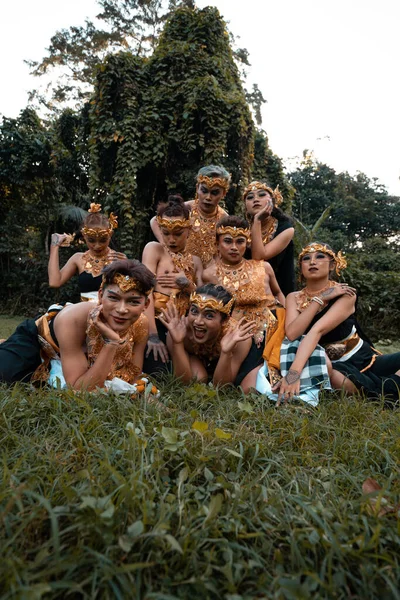 Javanonští Lidé Tradičními Tanečními Kostýmy Ležící Spolu Trávě Během Focení — Stock fotografie
