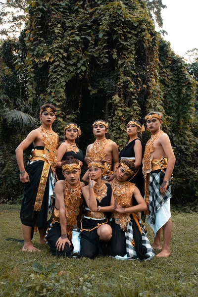 一群巴厘人在森林里表演完后身穿金色服装 面带笑容地摆姿势 — 图库照片