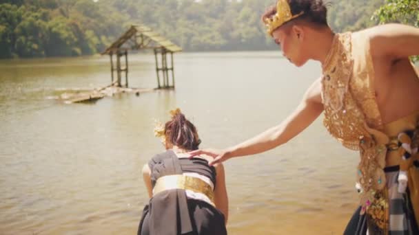 一位亚洲男子在湖边迎接一位漂亮的女人 她头戴金色的王冠 身穿黑色的连衣裙 脸上带着幸福的表情 — 图库视频影像