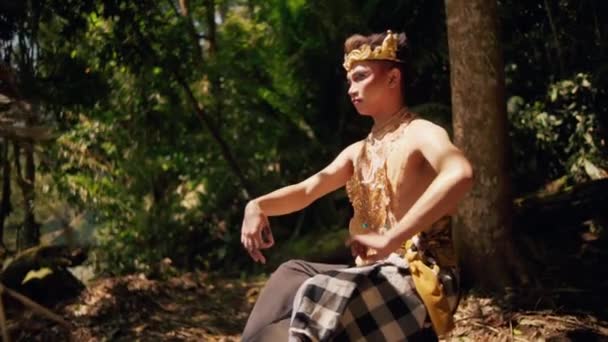 ジャングルの中で黄金の衣装を着て森から湖に歩くアジアの男 — ストック動画