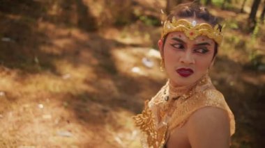 Asyalı bir adam bir şey ararken şaşkın ve şaşkın görünür ve ormanda tek başına koşar.