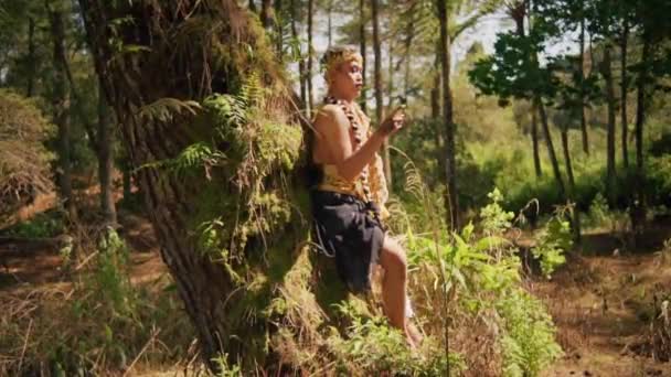 Homem Balinês Descansando Apoiando Árvore Enquanto Vestindo Uma Coroa Dourada — Vídeo de Stock