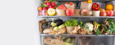 Açık buzdolabı dolusu vejetaryen sağlıklı meyve, sebze, antioksidan zengini, buzdolabında canlı yiyecekler olan pankart. Sağlıklı beslenme. Detoks. Diyet olsun. Sıfır atık market alışveriş konsepti. Boşluğu kopyala