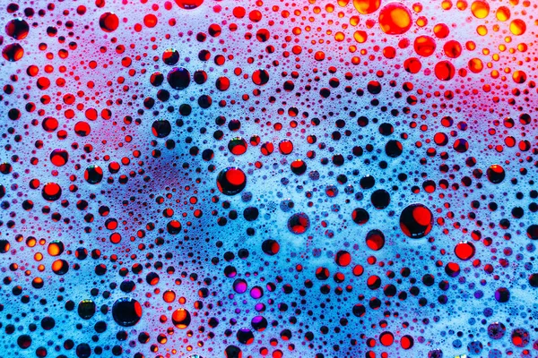 Soap foam. Background of dusty foam with bubbles of blue color for an inscription. Abstract multicolored, white, red, blue background. Colored soap foam texture. Shampoo foam with bubbles.