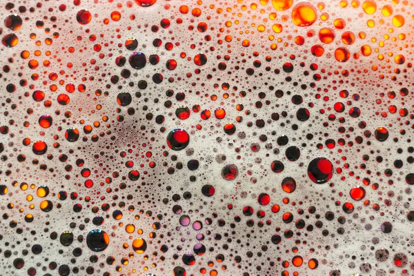 Soap foam. Background of dusty foam with bubbles of blue color for an inscription. Abstract multicolored, white, red, blue background. Colored soap foam texture. Shampoo foam with bubbles.