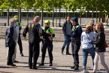 Belçika 'daki adliye meydanında düzenlenen gösteri sırasında polis memurları önünde silah tutan adam