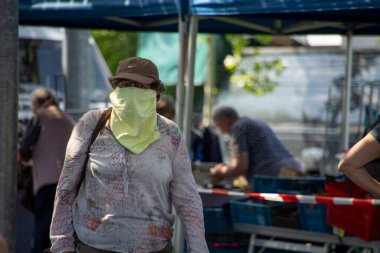 Kadın kep ve bez giyip salgın sırasında tüm yüzünü örtüyor.