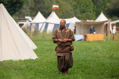 Viking adam tarihi canlandırma sırasında çadırların önünde çimlerin üzerinde yürüyordu.
