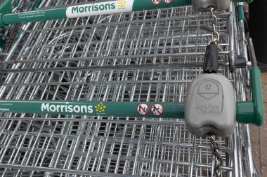 Closeup of Supermarket shopping trolley locking system at Morrisons supermarket