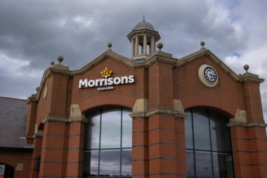 Entrance of Morrisons supermarket Starbeck store with clouds behind. clock and logo