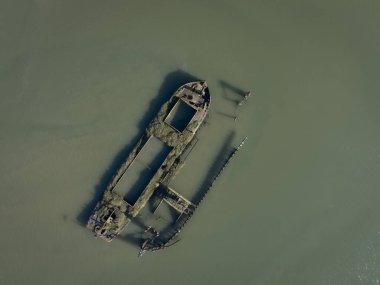 Drone aerial top down shot of an overgrown shipwreck in the waters of the blackwater estuary near maldon village in Essex, England