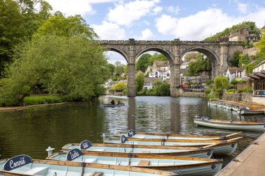 Boats on the river Nidd towards the viaduct in the town of Knaresborough in Yorkshire, UK in summertim