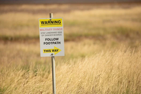 Warning, military range, follow footpath this way sign at military firing range in Norfolk, UK