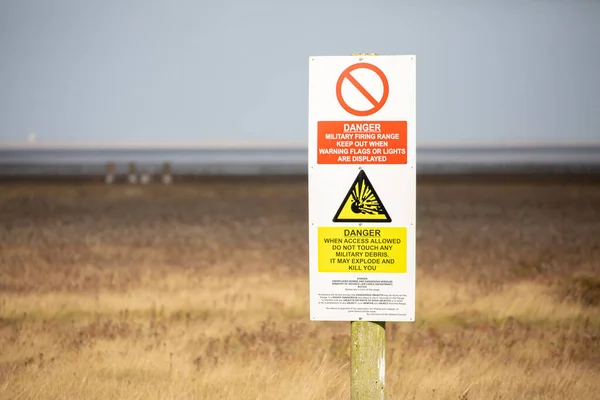 Danger, explosives sign in the grass at military firing range in Norfolk, UK