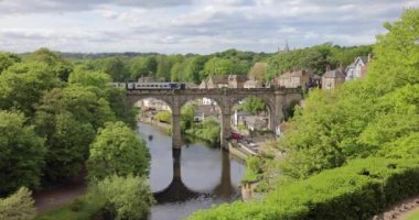 Train crossing Knaresborough viaduct over the river Nidd in Yorkshire on a summer day