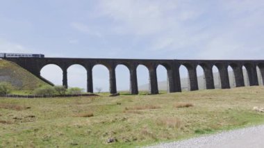 Train crossing Ribblehead Viaduct or Batty Moss on a sunny day
