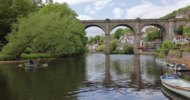 Mother and child enjoying a relaxing leisure tourist boat ride, paddling on the River Nidd near Knaresborough viaduct