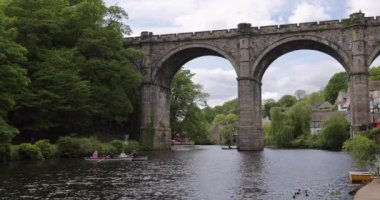 People in tourist boat on the River Nidd near Knaresborough viaduct enjoying a relaxing day while ducks are swimming on the water