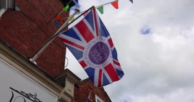 UK Union Jack for the Queen 2020 Jubilee on a wall waving in the wind and bird flying up
