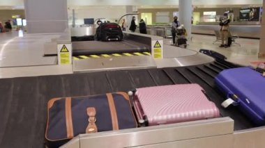Suitcases and bags dropping and carried by convey belt or carousel at Alicante International airport in Spain