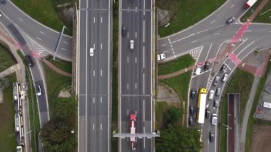 Yoğun bir kavşaktaki trafik, trafik ışıkları ve otoyoldaki hızlı görüntüler. İHA 'nın tepeden aşağı görüntüsü