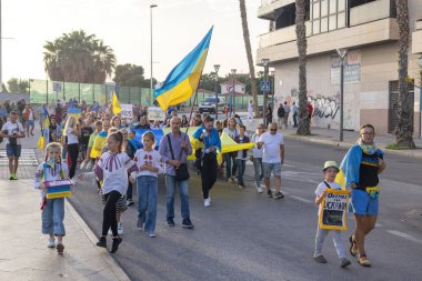 Sokaktaki çocukların önünde Rusya 'yı ve Ukrayna' daki savaşı protesto ediyorlar. Torrevieja 'da yürüyüş sırasında Ukrayna bayrakları sallayan protestocular