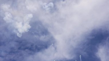 Gün boyunca mavi bir gökyüzünün arkasında ağır çekimde havai fişekler