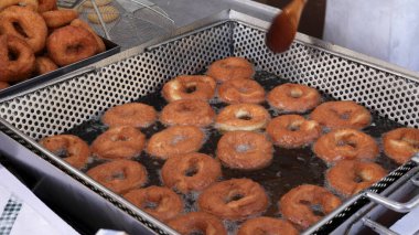 Yerel bir gıda pazarında kızgın yağda pişerken tavada taze çörek pişirmek.