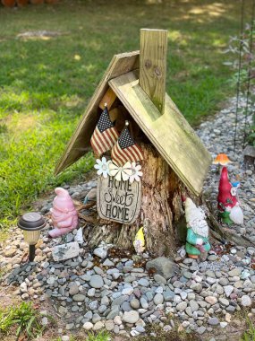 a small wooden gnome house on top of tree stump