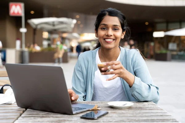 Portrait Smiling Indian Woman Freelancer Using Laptop Drinking Coffee Sitting — стокове фото