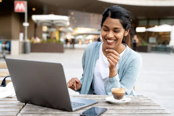 Young Confident Indian business woman using laptop computer working, planning startup, having video call sitting at workplace, laughing. Successful business. Online meeting, video conference concept