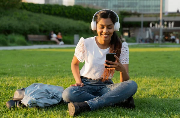 Smiling Indian Woman Holding Mobile Phone Listening Music Wireless Headphones — Stockfoto