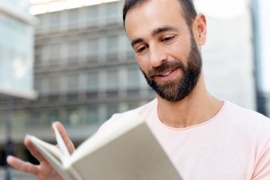 Düşünceli İspanyol öğrencinin yakın plan portresi. Okuyor, kitap okuyor, üniversite kampüsünde dil öğreniyor. Eğitim kavramı  